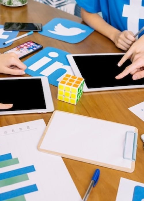 social-media-team-using-digital-tablet-with-social-media-icons-desk_23-2147847541